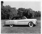 1952 Packard touring sedan, right side view, parked on grass, couple in background