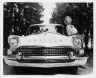 1957 Packard sedan, front view, female standing at driver's door
