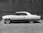 1955 Packard convertible, left side view, top raised, parked next to brick wall