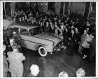 1951 Packard 4-door sedan admired by crowd at automobile show