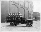 Early 1900s Packard truck used by Goebel Brewing Co. full of wooden beer barrels, parked on street