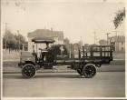 Early 1900s Packard truck, parked on residential street, man behind wheel