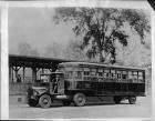 1922 Packard truck with City of Detroit bus trailer, two men in front cab, passengers in back
