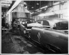 1955 Packard Clipper metal bodies on assembly line, entering spraying tunnel